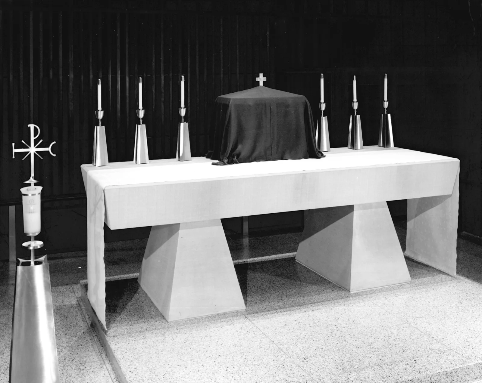 The two-ton buff Indiana limestone altar of St. Raymond, enclosed by the communion rail, beneath the suspended monstrance-shaped canopy.