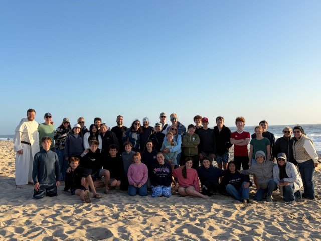 Teens and adult leaders from BEaST Youth Ministry gathered on the beach at sunset.